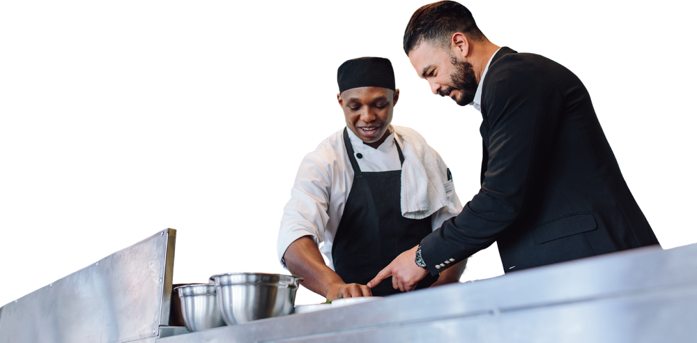 Un chef y un consultor revisando juntos una preparación en cocina